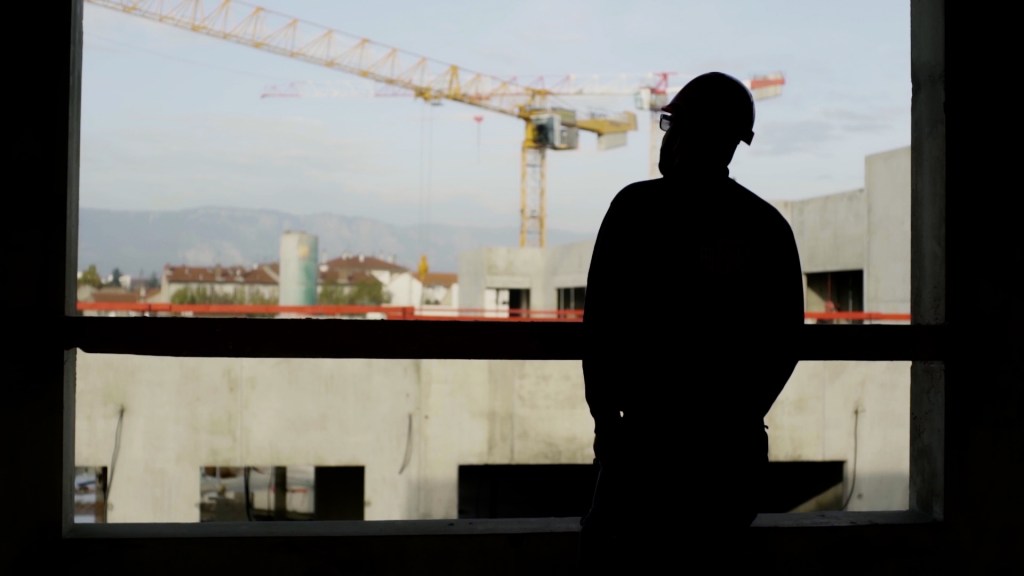 Ouvrier de chantier regardant une grue Ferreira Bâtiment.