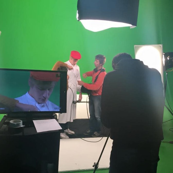 Vidéaste captant des images sur fond vert pour un film institutionnel.